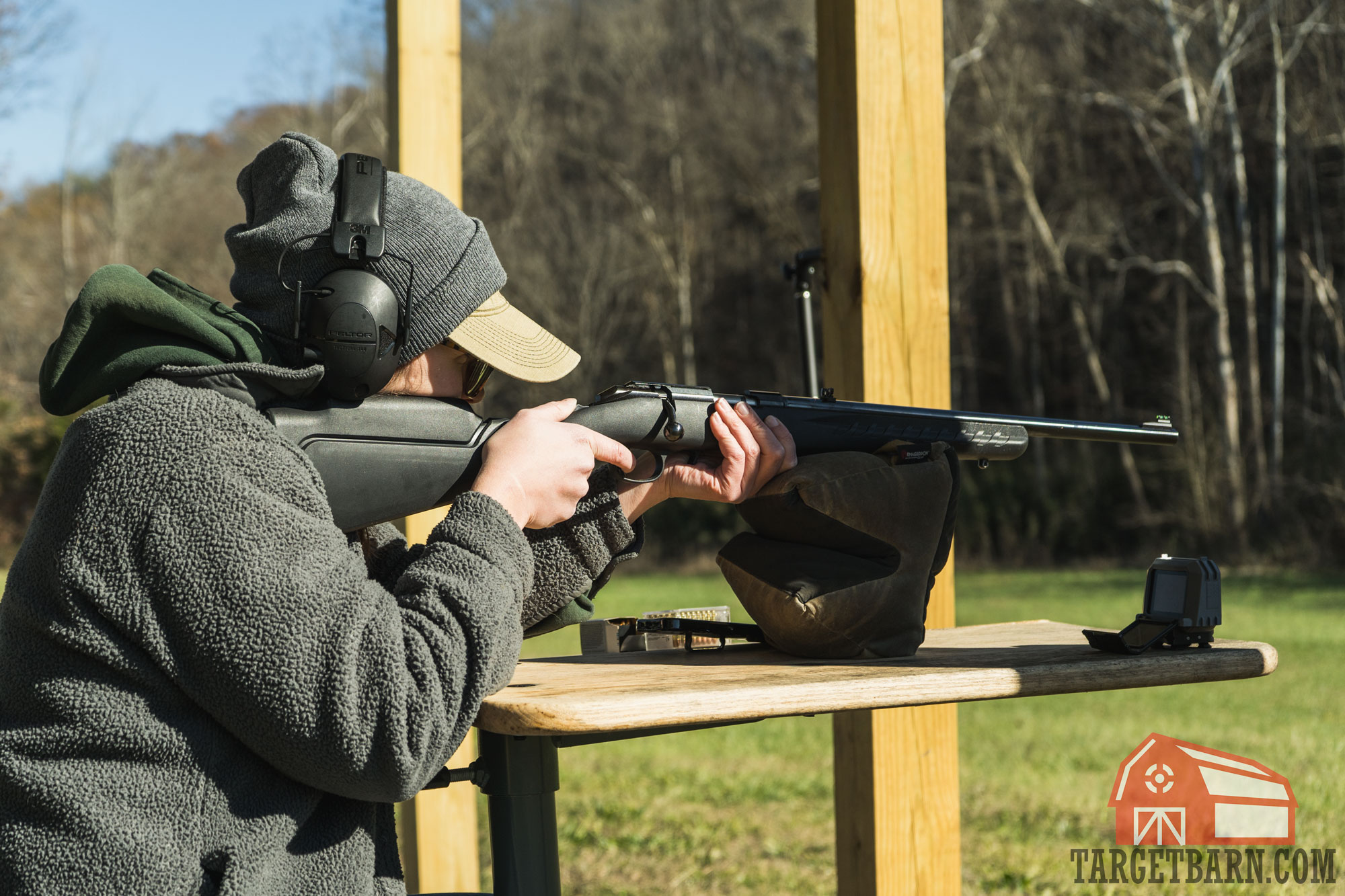 a woman using a ruger american 22 magnum rifle to chronograph ammo at the range