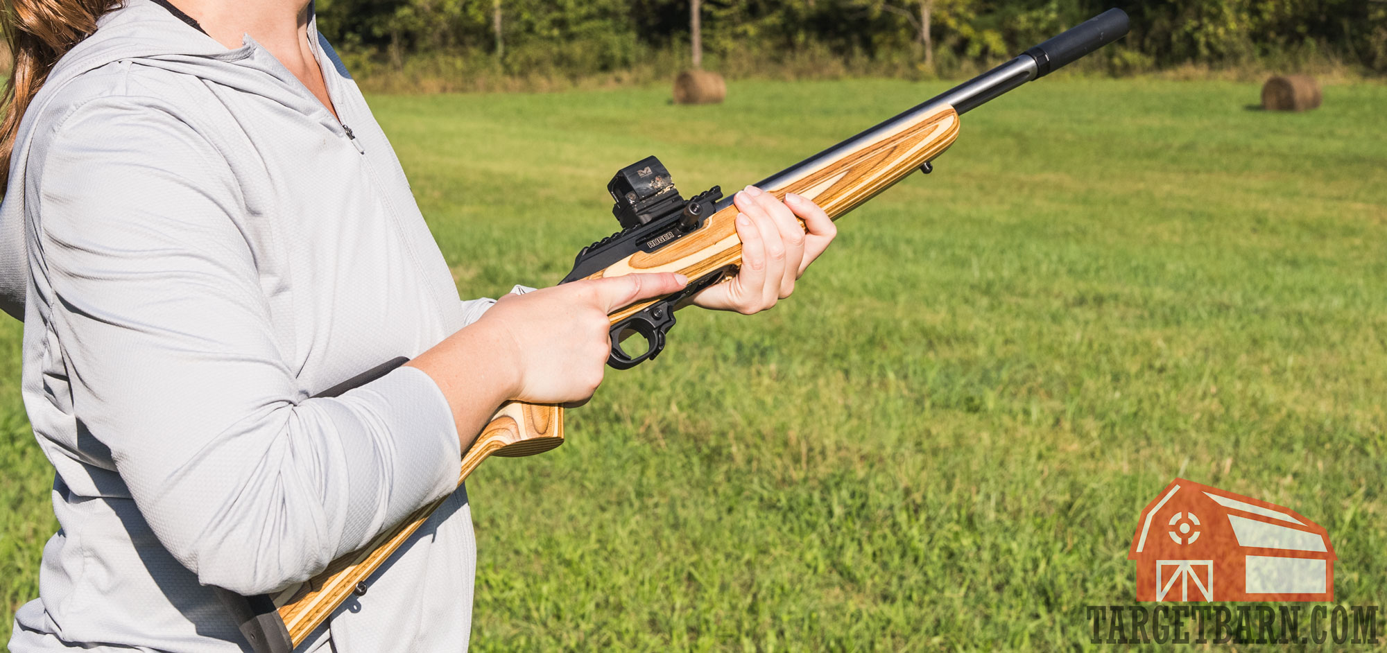 holding a suppressed .22lr rifle for varmint hunting