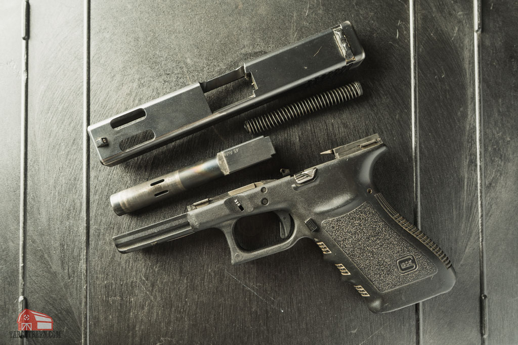 a disassembled glock 21c with a ported barrel