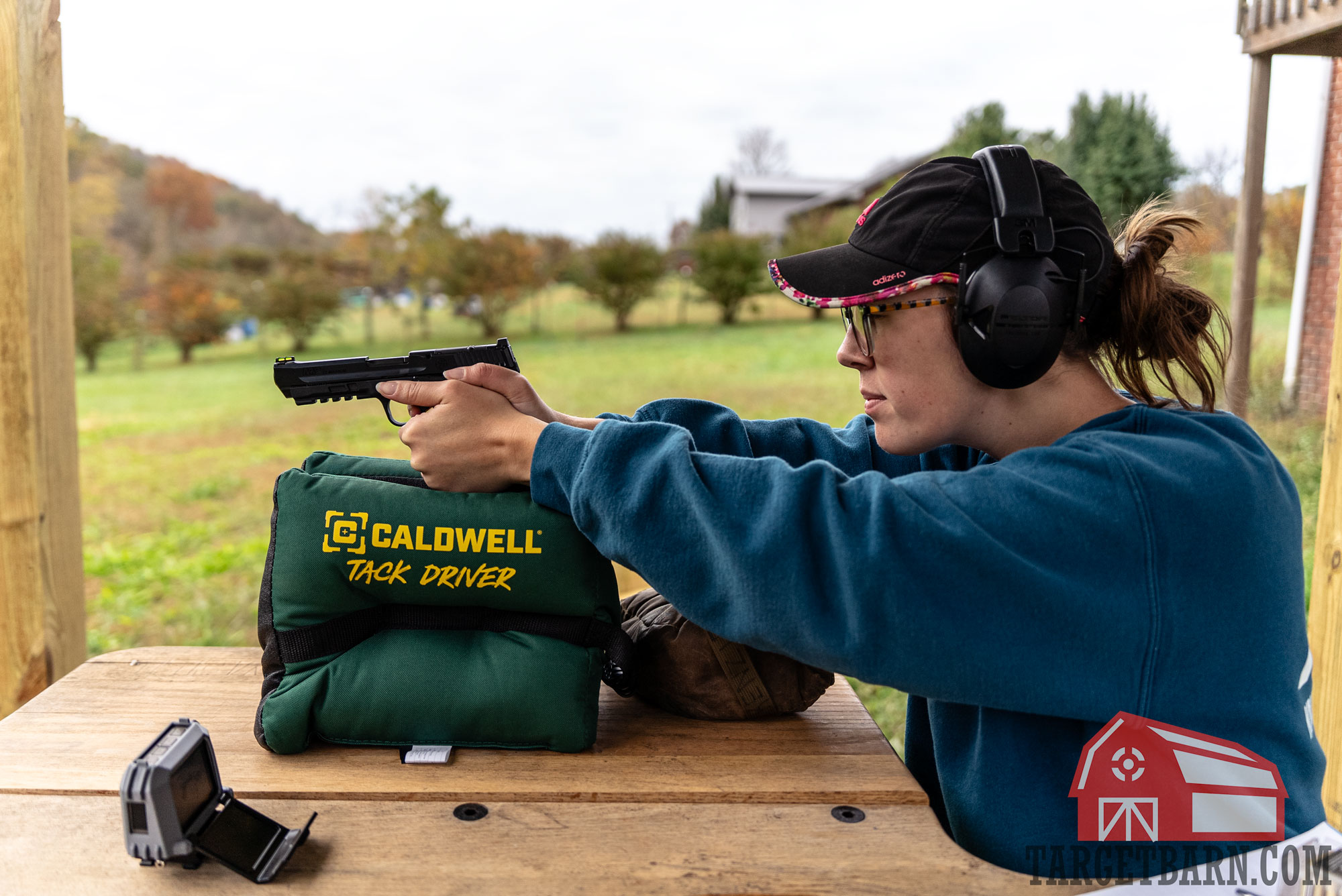 a woman shooting a .22 mag pistol at the range 