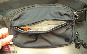 showing the open front pocket of the vertx everyday fanny pack