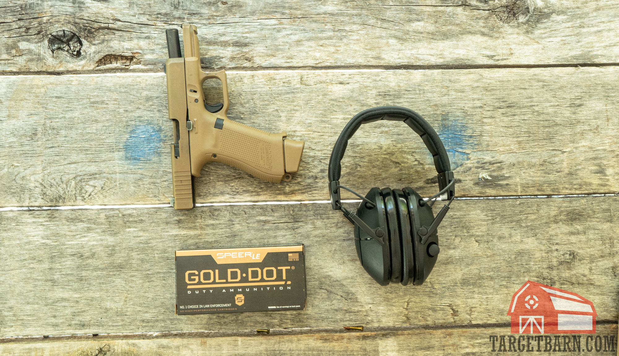a glock 19x, box of gold dot, and ear protection sitting on a table at the range