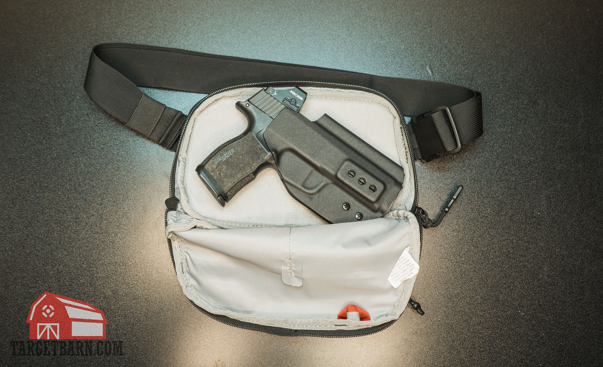 a gun and holster inside the gun compartment of the vertx everyday fanny pack