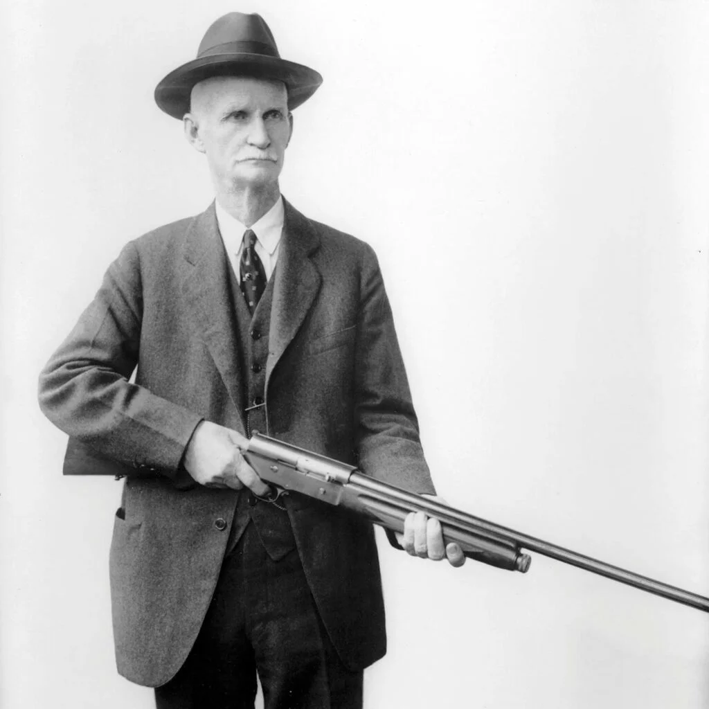 john moses browning using trigger finger discipline when posing with a rifle