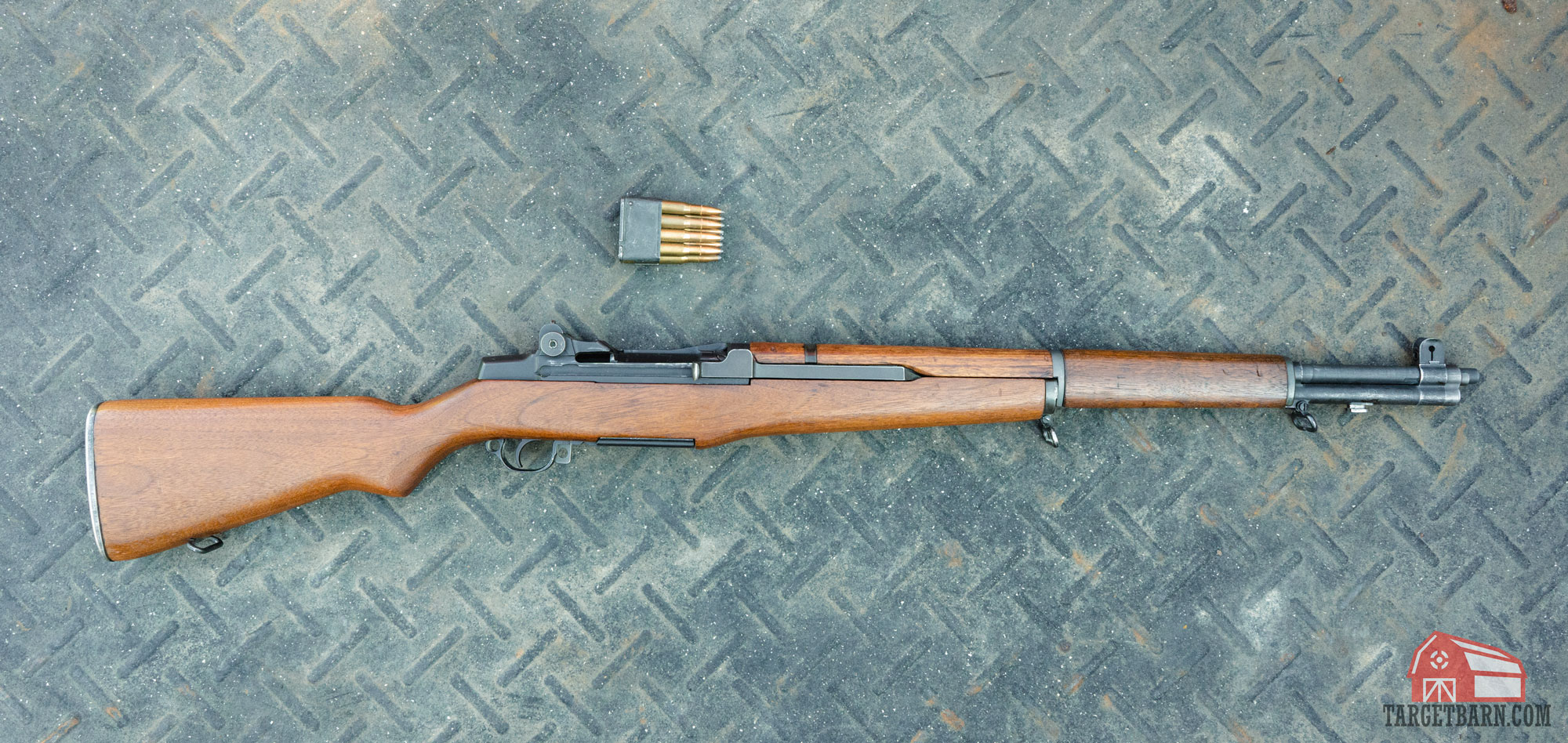 an m1 garand on the ground with an 8 round .30-06 springfield en bloc clip next to it