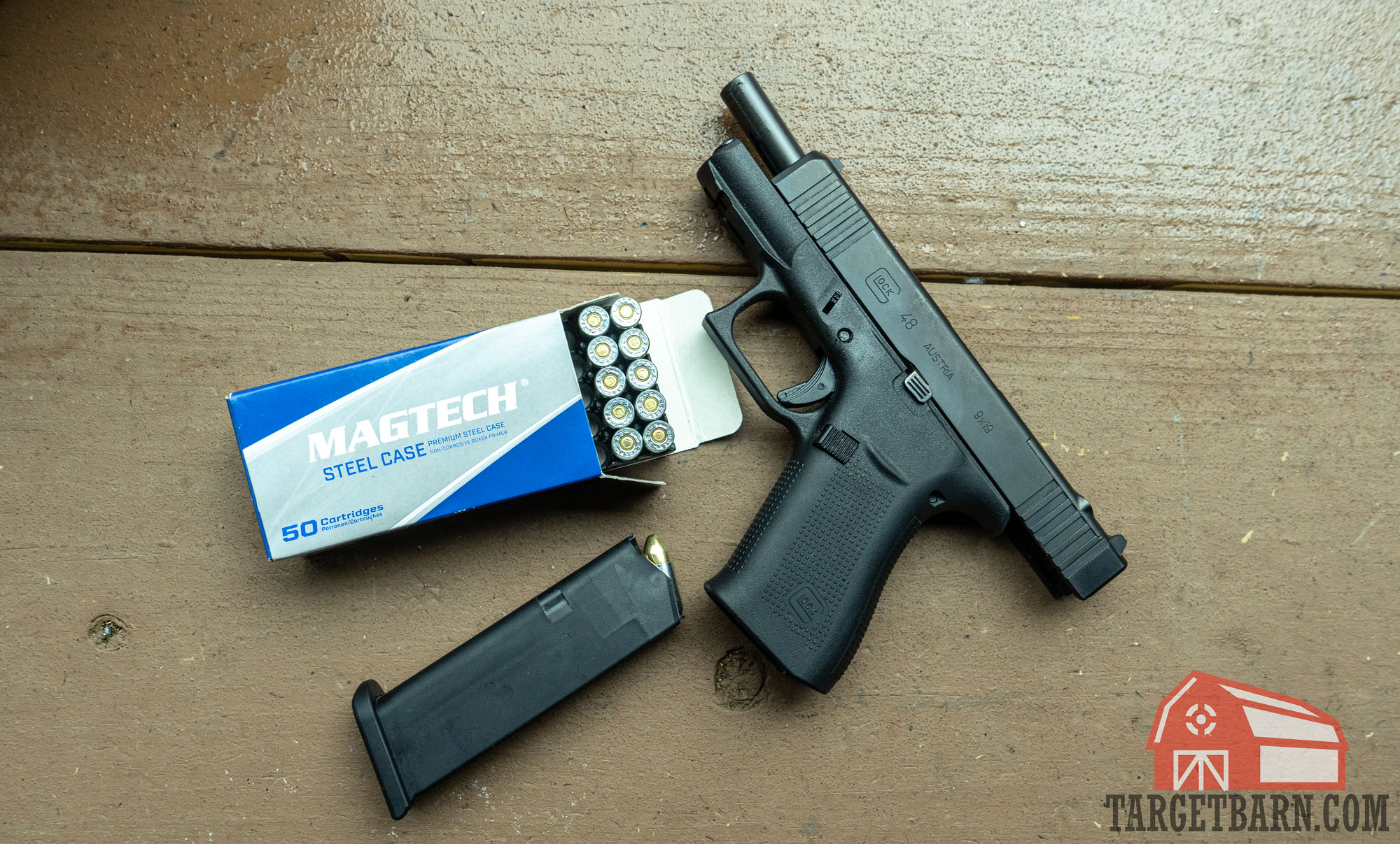 an open box of magtech steel case 9mm and a glock 48 on the table at the range