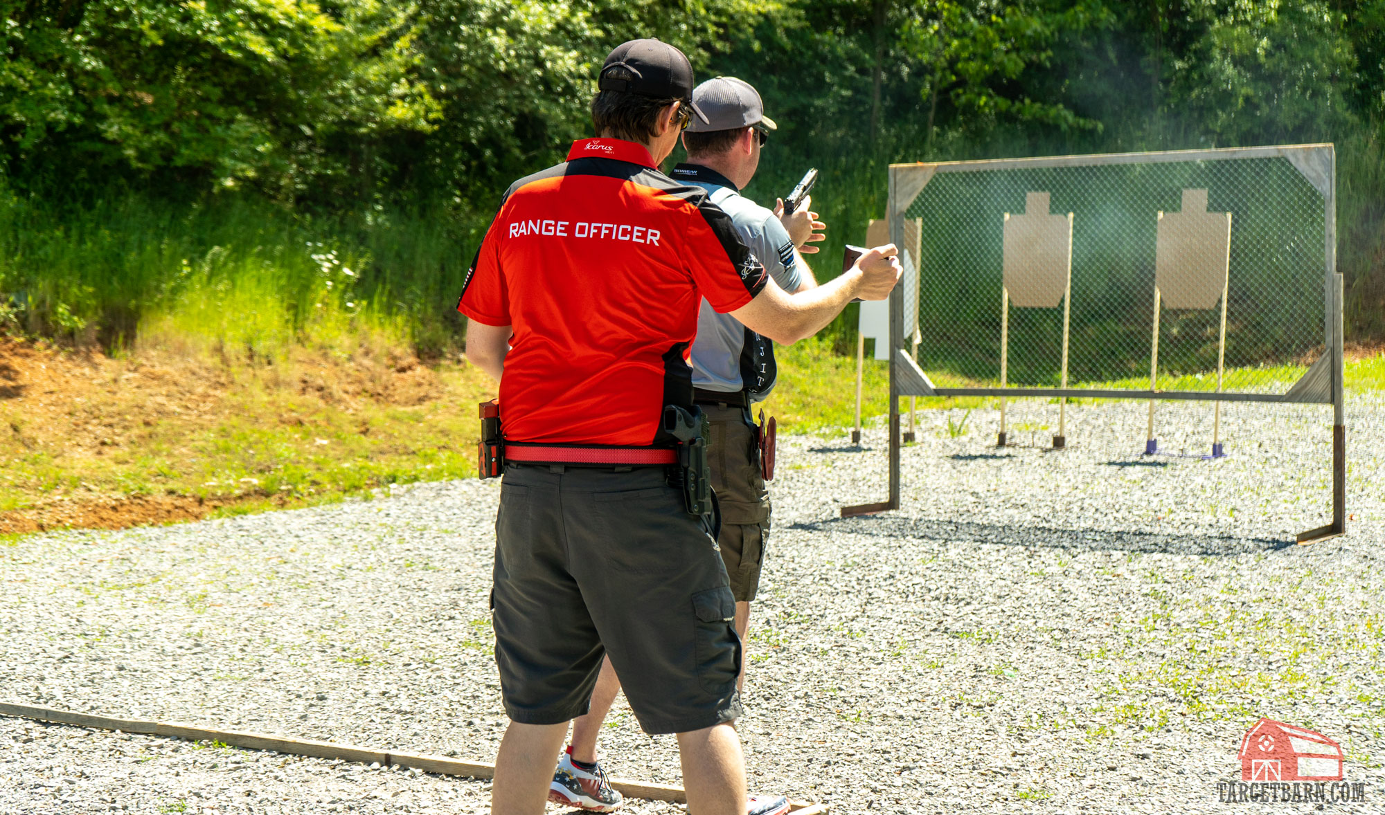 a range officer timing a shooter during a stage at a uspsa match