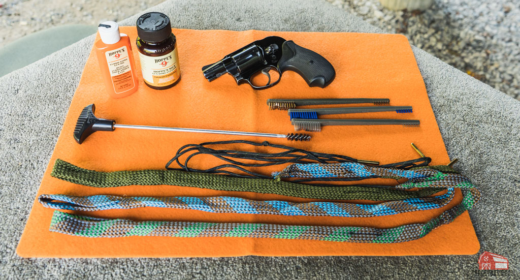 a revolver and cleaning supplies on a cleaning mat