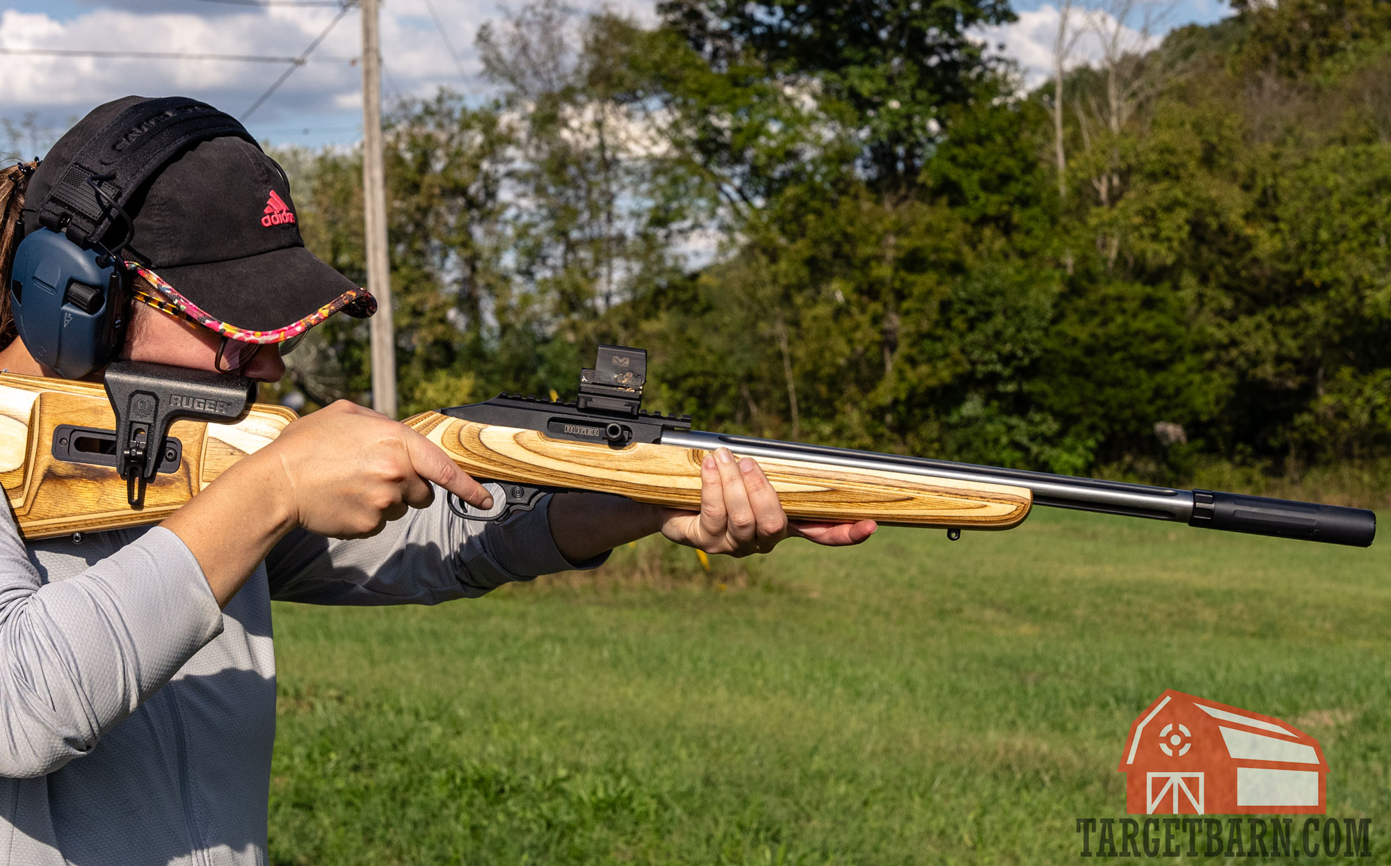 a woman shooting a suppressed ruger 10/22 at the range for the cci blazer .22lr review