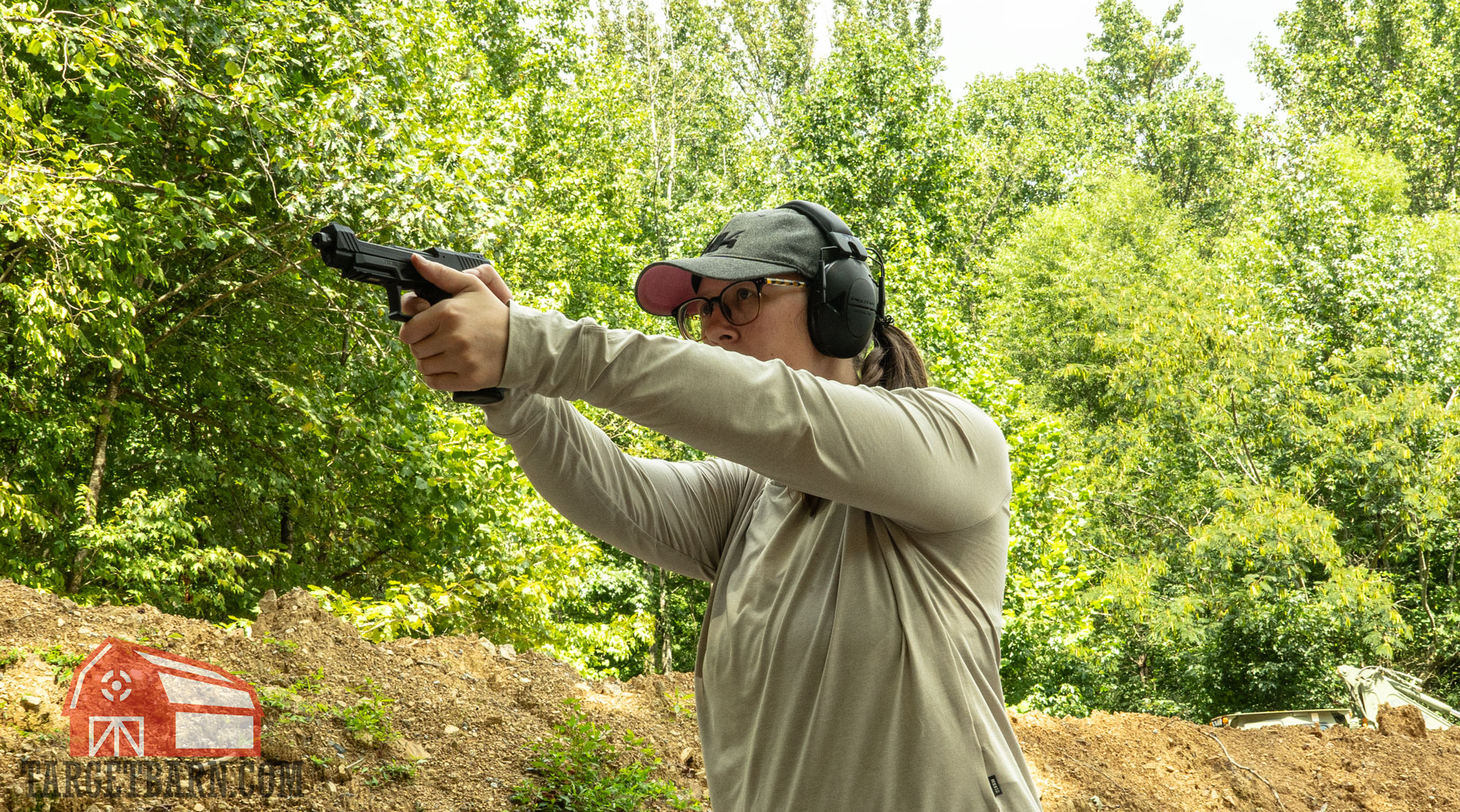 the author shooing a taurustx 22 pistol at the range to find the best .22lr ammo for pistols