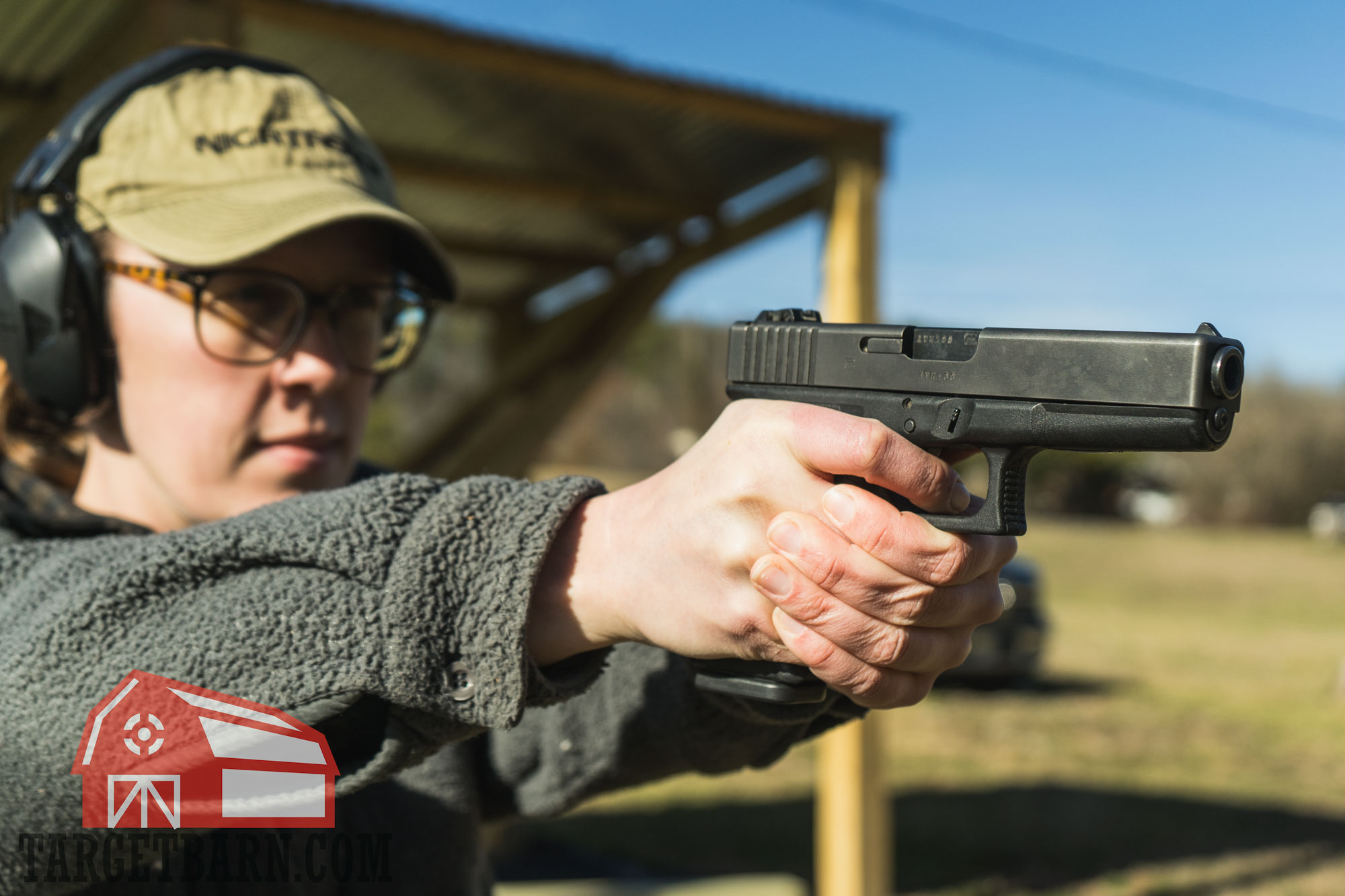 a woman shooting a 10mm pistol at the range