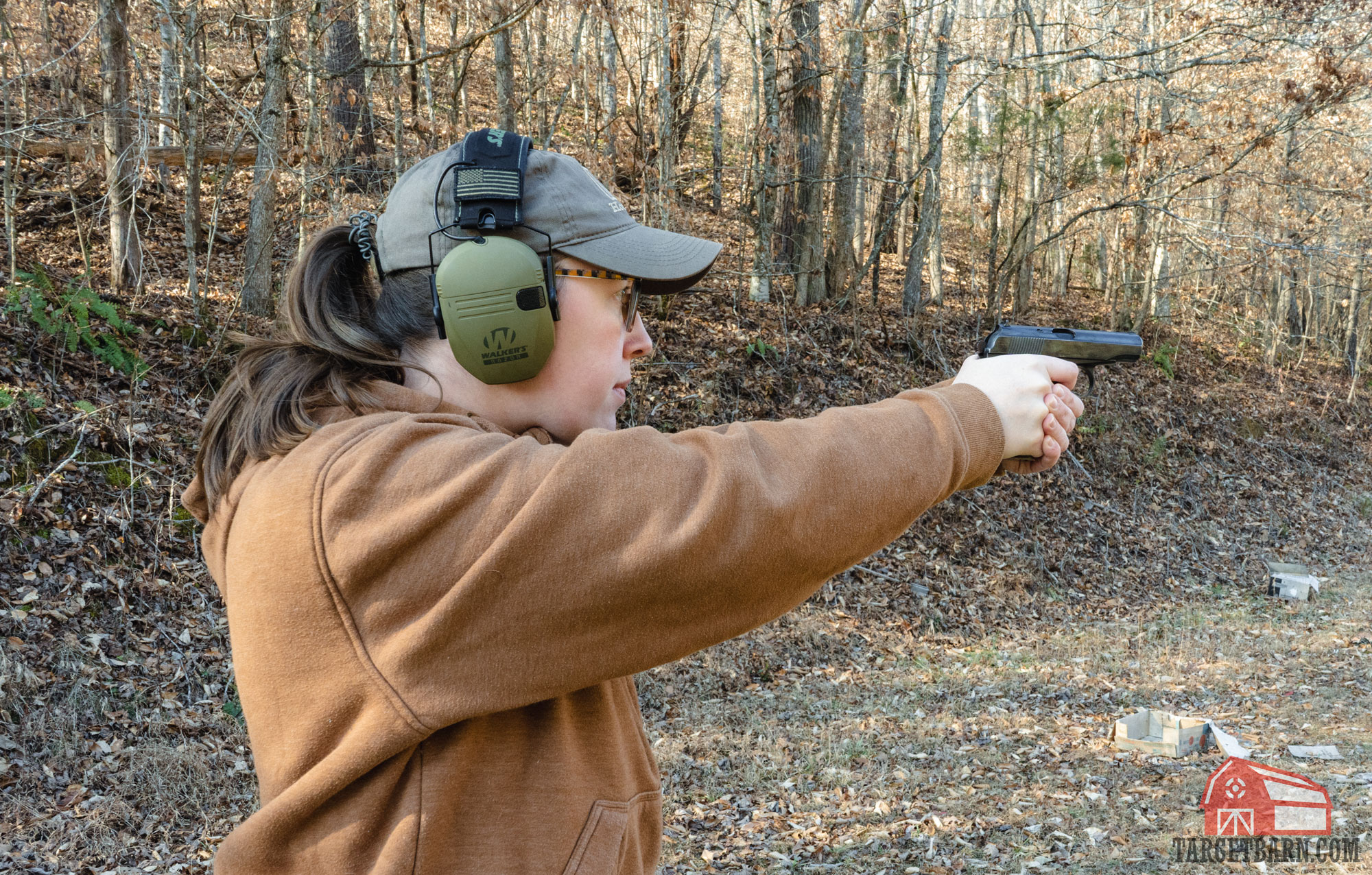 a woman shooting a 9mm makarov pistol at the range