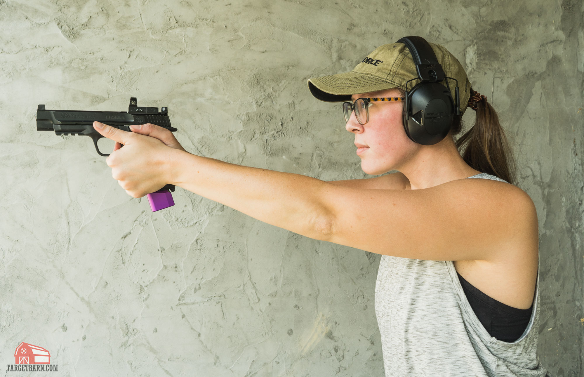 mckenzie shooting a gun with a red dot sight