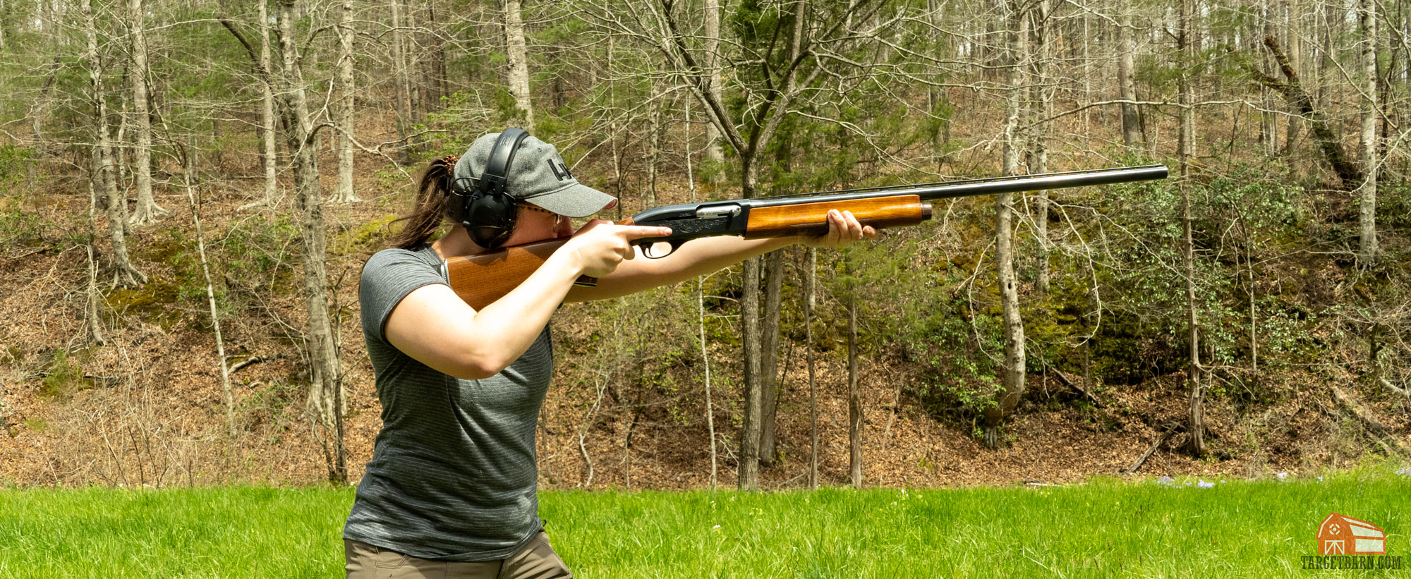 a girl shooting a shotgun