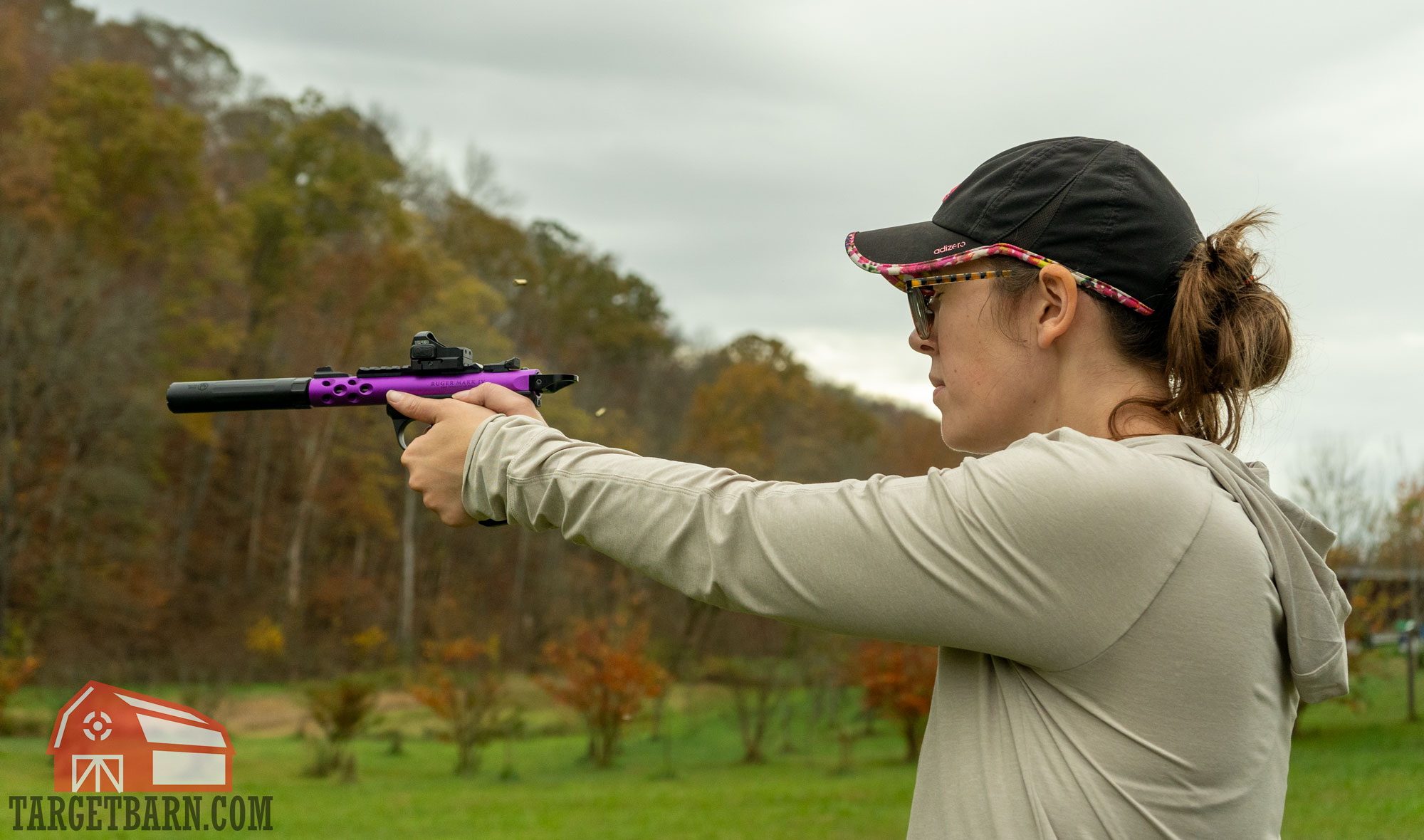 a woman shooting a ruger mark iv lite pistol with a suppressor at the range