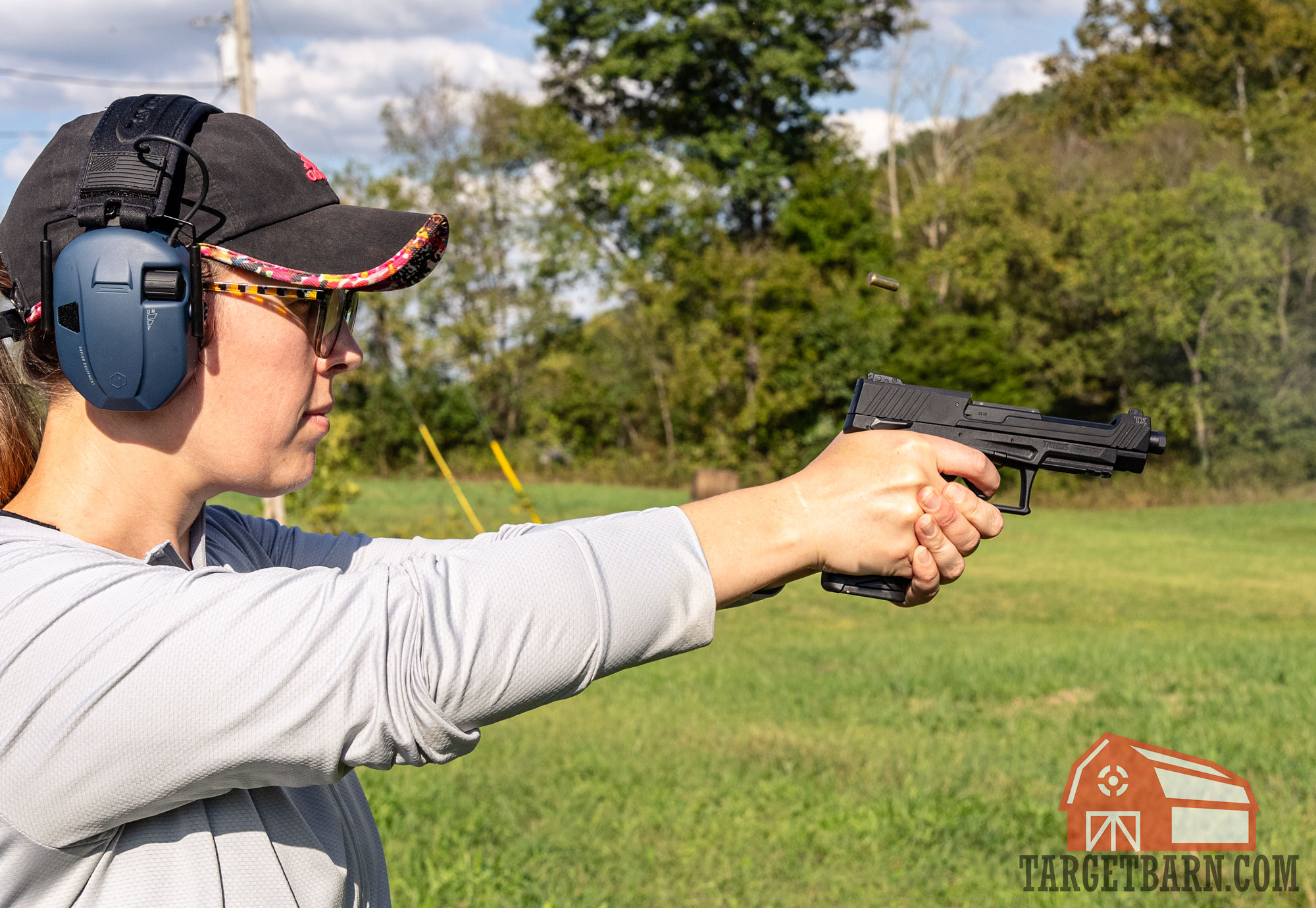 a woman shooting a taurustx 22 pistol at the range